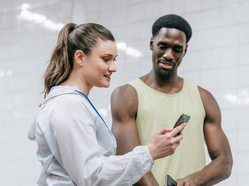 A coach showing a client something on a phone